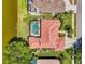 Aerial view of a home with a red tile roof, pool, and landscaped backyard bordering a lake at 407 Fieldstone Dr, Venice, FL 34292