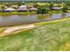 Aerial view of a waterfront home on a golf course with a sand trap and beautiful landscaping at 407 Fieldstone Dr, Venice, FL 34292