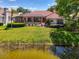 Charming backyard with a screened-in pool, lush lawn, and tranquil waterfront view from the home at 407 Fieldstone Dr, Venice, FL 34292