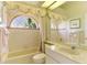 Well-lit bathroom with a tub-shower combination, a decorative window, and a vanity area at 407 Fieldstone Dr, Venice, FL 34292