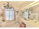 Elegant bathroom with chandelier, large tub, vanity, and natural light from decorative window at 407 Fieldstone Dr, Venice, FL 34292