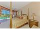 Bedroom features a four-poster bed, ceiling fan and views of the pool at 407 Fieldstone Dr, Venice, FL 34292