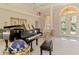 Entry foyer with piano, complemented by decorative front door with heron design at 407 Fieldstone Dr, Venice, FL 34292