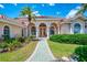 Beautiful front entrance featuring arched entryways, lush landscaping, and a brick paved walkway at 407 Fieldstone Dr, Venice, FL 34292