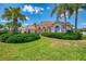 Charming one-story residence featuring mature landscaping, lush lawn, and covered front entry at 407 Fieldstone Dr, Venice, FL 34292