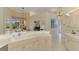 Bright kitchen with long countertop and view into dining area, pool and golf course at 407 Fieldstone Dr, Venice, FL 34292