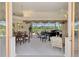 Bright living room features a piano, large windows overlooking the manicured backyard and dining table at 407 Fieldstone Dr, Venice, FL 34292