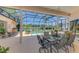 Relaxing outdoor dining area overlooking a screened-in pool and scenic golf course views at 407 Fieldstone Dr, Venice, FL 34292