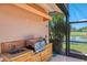 Convenient outdoor kitchen featuring a built-in grill, sink, and beautiful views of the golf course at 407 Fieldstone Dr, Venice, FL 34292