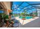 Relaxing screened-in pool area with lounge chairs and picturesque golf course and lake views at 407 Fieldstone Dr, Venice, FL 34292