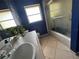 Bathroom with blue walls, shower stall and tiled vanity with updated fixtures at 4170 Prudence Dr, Sarasota, FL 34235