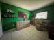 Bedroom featuring tile floors, green walls, blinds, and a sitting chair at 4170 Prudence Dr, Sarasota, FL 34235