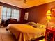 A well-lit bedroom featuring tile flooring, a comfortable bed, and a side table with a lamp at 4170 Prudence Dr, Sarasota, FL 34235