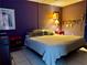 A well-lit bedroom featuring tile flooring, a comfortable bed, and a side table with a lamp at 4170 Prudence Dr, Sarasota, FL 34235