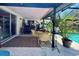 Covered patio area with seating near a sparkling pool and lush greenery at 4170 Prudence Dr, Sarasota, FL 34235