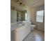 Well-lit bathroom with ample vanity storage, a large mirror, and a tile floor, for a clean aesthetic at 4456 Callaway St, Port Charlotte, FL 33981
