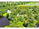 Aerial view of a home with a private pond and surrounded by mature trees at 4576 Cooper Rd, Sarasota, FL 34232