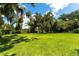 Lush backyard with a sprawling lawn and mature trees, perfect for outdoor activities at 4576 Cooper Rd, Sarasota, FL 34232