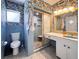 Bathroom featuring blue tile, gold accents, and a unique wallpaper design at 4576 Cooper Rd, Sarasota, FL 34232