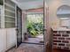 View from the home into the garden featuring double doors and a brick accent wall at 4576 Cooper Rd, Sarasota, FL 34232