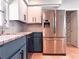 Modern kitchen with stainless steel refrigerator, marble countertops, and two-tone cabinetry at 4576 Cooper Rd, Sarasota, FL 34232