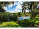 Tranquil pond view framed by trees and lush vegetation, enhancing the property's peaceful ambiance at 4576 Cooper Rd, Sarasota, FL 34232