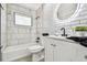 Modern bathroom featuring stylish tile work, a bathtub, and a sleek vanity with a round LED mirror at 4741 Watkins Ave, Sarasota, FL 34233