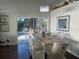 Bright dining room featuring hardwood floors, a modern chandelier, and sliding door access to the pool area at 4907 Kilty E Ct, Bradenton, FL 34203