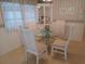 Bright dining area with glass table, white chairs, and large windows at 4920 Boca Raton Ave, Sarasota, FL 34234