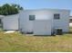 Exterior view of a white home with a shed and an air conditioning unit at 4920 Boca Raton Ave, Sarasota, FL 34234