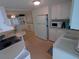 Functional kitchen featuring white appliances, cabinets, and a cozy breakfast bar at 4920 Boca Raton Ave, Sarasota, FL 34234