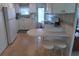Efficient kitchen featuring white cabinets, appliances, and a convenient breakfast bar with seating at 4920 Boca Raton Ave, Sarasota, FL 34234