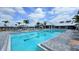 A large community pool area showcases a clear blue swimming pool, lounge chairs, and umbrellas at 4970 Oyster Pearl St, Lakewood Ranch, FL 34211