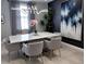 Modern dining room with marble table, grey chairs, statement lighting, and decorative wall art at 4970 Oyster Pearl St, Lakewood Ranch, FL 34211