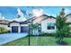 Charming single-Gathering home with a manicured lawn, gray exterior, well-kept landscaping, and a paved driveway at 4970 Oyster Pearl St, Lakewood Ranch, FL 34211