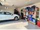 Organized garage featuring a car, storage shelves, and ample space for parking and storage at 4970 Oyster Pearl St, Lakewood Ranch, FL 34211