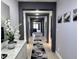 Elegant hallway with gray walls, modern decor, and an artistic rug leading to a brightly lit living area at 4970 Oyster Pearl St, Lakewood Ranch, FL 34211