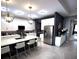 Modern kitchen with island, breakfast bar, stainless steel appliances and statement lighting fixtures at 4970 Oyster Pearl St, Lakewood Ranch, FL 34211