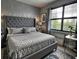 Bedroom with tufted headboard, decorative wallpaper, and bright window light at 4970 Oyster Pearl St, Lakewood Ranch, FL 34211
