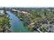 Aerial view of a waterfront home featuring a boat dock, lush trees, and scenic canal views, perfect for boating at 5033 Oxford Dr, Sarasota, FL 34242
