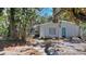A white house with a blue door and flag surrounded by lots of mature trees and shrubs at 5033 Oxford Dr, Sarasota, FL 34242