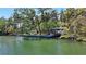 Tranquil waterfront property showing boat dock, lush trees, and serene water views for peaceful living and boating at 5033 Oxford Dr, Sarasota, FL 34242