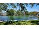 Beautiful waterfront view with lush trees and a glimpse of the home, offering a serene and picturesque setting at 5033 Oxford Dr, Sarasota, FL 34242