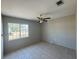 Bright bedroom features tile flooring, a ceiling fan, and a large window letting in plenty of natural light at 5315 Malamin Rd, North Port, FL 34287