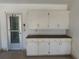 Garage with built-in storage cabinets and shelving, adjacent to an exterior door with a window for added convenience at 5315 Malamin Rd, North Port, FL 34287