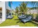 A backyard with an artificial lawn, palm trees, lounge chairs, and ping pong table at 540 S Polk Dr, Sarasota, FL 34236