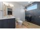 Stylish bathroom with a glass-enclosed shower, blue vanity with modern fixtures, and a striking gold mirror at 540 S Polk Dr, Sarasota, FL 34236