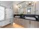 Modern bathroom with double sinks, wooden cabinets, and a luxurious shower with marble walls and brass fixtures at 540 S Polk Dr, Sarasota, FL 34236