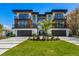 Stunning modern home featuring multi-level balconies, a stone facade, and a well-manicured front lawn at 540 S Polk Dr, Sarasota, FL 34236