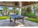 Entertaining outdoor billiards area with stylish billiard table, covered patio, and manicured landscaping at 540 S Polk Dr, Sarasota, FL 34236